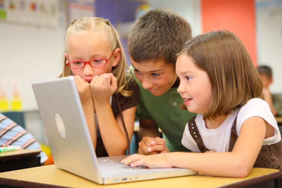 Elementary School Kids Gathered Around a Laptop